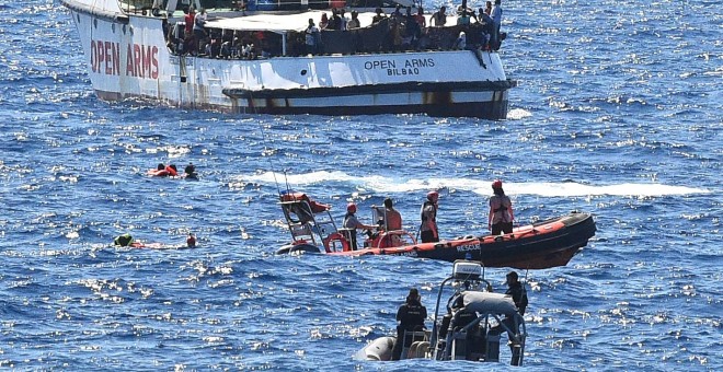 Varios migrantes saltan por la borda del Open Arms para llegar a nado a la isla italiana de Lapedusa, desesperados tas 19 días encerrados en el barco español.- REUTERS