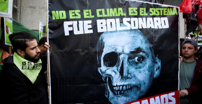 Manifestantes sostienen una pancarta contra Bolsonaro en Buenos Aires debido a los incendios que arrasan el Amazonas. /REUTERS