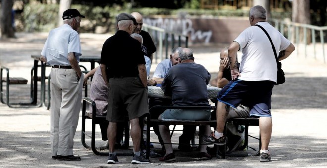 Varios pensionistas juegan al dominó en un parque de Madrid. E.P./Eduardo Parra