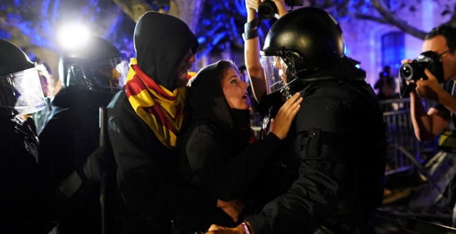 Una manifestante media ante un agente durante las protestas junto al Parlament. - REUTERS