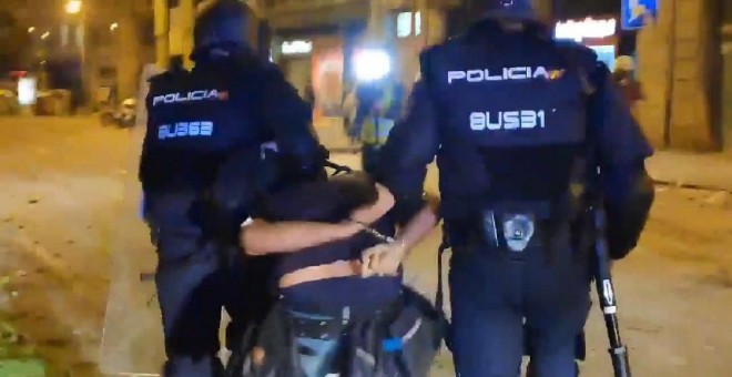 Momento en el que dos Mossos se llevan detenido al fotoperiodista Albert García.