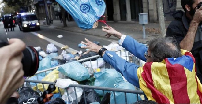Manifestantes arrojan bolsas de basura a la Delegación del Gobierno durante las protestas en Barcelona. / JESÚS DIGES (EFE)