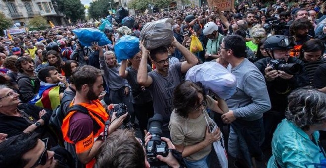 Milers de persones porten bosses de brossa per ser llançades a la vora de la Delegació del govern espanyol a Barcelona. EFE / Enric Fontcuberta
