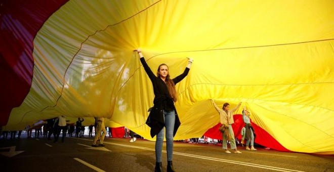 Decenas de personas sostienen la bandera de España de 1.000 metros cuadrados -50 de largo por 20 de ancho y con unos 130 kilos de peso, durante la concentración convocada por Vox para defender la 'unidad de España, el orden constitucional y la convivencia