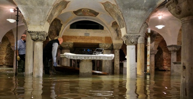Operarios vacían la cripta de la basílica de San Marcos, donde el nivel del agua llegó a los 110 centímetros durante la noche. REUTERS/Manuel Silvestri