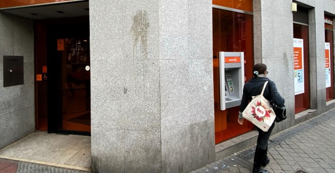 Una mujer camina junto a una oficina del Bankinter. / EUROPA PRESS (Eduardo Parra)