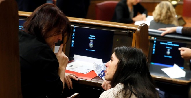 La diputada de Unidas Podemos Irene Montero  conversa con la diputada del PSOE Adriana Lastra, durante la sesión constitutiva de la Cámara Baja. EFE/Ballesteros