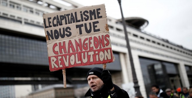 Un manifestante parisino muestra una pancarta contra los recortes en las pensiones. REUTERS/Benoit Tessier