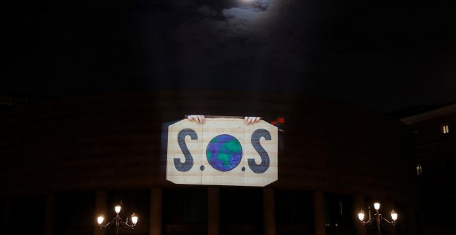 Activistas de Greenpeace proyectan un vídeo en la fachada de el Senado en Madrid para reclamar acciones contra la crisis climática. REUTERS/Susana Vera