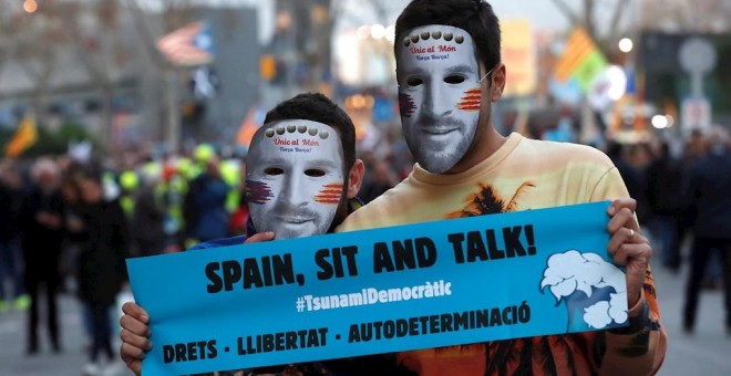 18/12/2019.- Dos manifestantes con caretas del futbolista Messi en los aledaños del Camp Nou, / EFE - TONI ALBIR