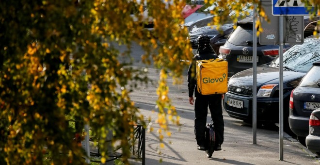 Un repartidor del Glovo sobre un patinete eléctrico en Kiev./ Gleb Garanich (Reuters)
