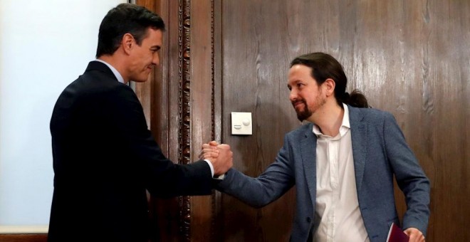 30/12/2019.- El candidato a la investidura, Pedro Sánchez (i), y el líder de Podemos, Pablo Iglesias (d), estrechan su s manos durante el acto de firma del acuerdo programático. / EFE - JUANJO MARTÍN