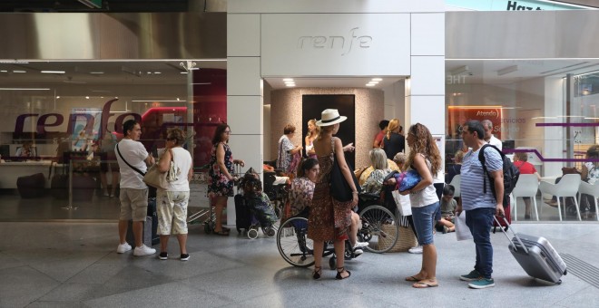 Pasajeros en la estación de tren Puerta de Atocha de Madrid junto a una oficina de Renfe. / EUROPA PRESS