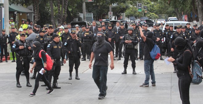 14/01/2020.- Estudiantes son rodeados por miembros de la Policía durante una protesta contra la investidura de Alejandro Giammattei como mandatario del Guatemala. EFE/ Norvin Mendoza