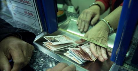 Un hombre compra varios décimos en una administración de lotería en Valencia. EFE/Manuel Bruque.