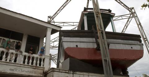 En Lampulo, un barrio de pescadores de Banda Aceh, un barco permanece incrustado en el techo de una casa. - EFE