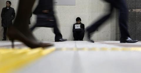 Un hombre con su portatil en una estación de metro en el distrito financiero de Tokyo. REUTERS/Yuya Shino