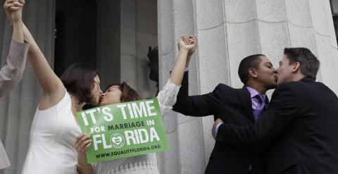 Parejas se besan para festejar el anuncio de la legalización del matrimonio entre personas del mismo sexo en el estado de Florida. /REUTERS