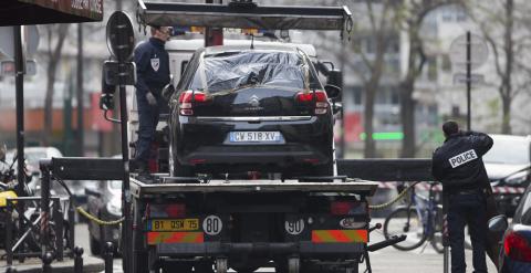 Agentes de Policía retiran el supuesto coche utilizado por los atacantes a la sede de 'Charlie Hebdo' en París. - EFE
