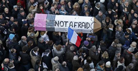 Citizens carrying a giant cardboard pencil reading 'Not Afraid' take part in a Hundreds of thousands of French citizens solidarity march (Marche Republicaine) in the streets of Paris January 11, 2015. French citizens will be joined by dozens of foreign le