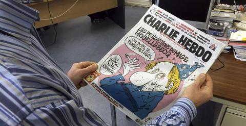 Un periodista sujeta la portada del último número de 'Charlie Hebdo' antes del atentado. - EFE