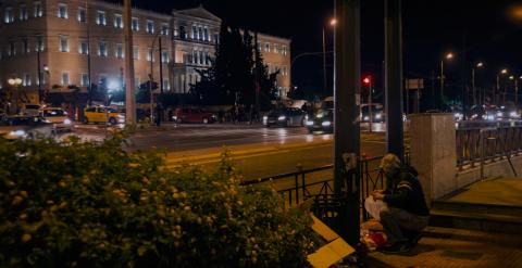 Un hombre hurga en la basura frente al Parlamento heleno.
