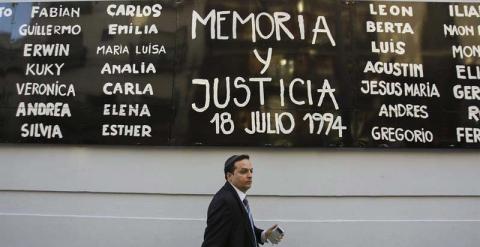 Un hombre camina bajo un cartel durante una manifestación para exigir justicia tras la muerte del fiscal argentino Alberto Nisman en el exterior de la sede de la AMIA en Buenos Aires. - EFE