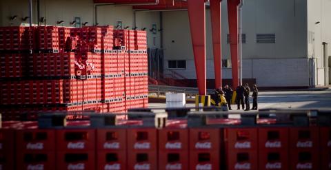 Los vigilantes de seguridad de planta de Coca-cola de Fuenlabrada conversan en las inmediaciones de la fábrica, que lleva un año cerrada. -JAIRO VARGAS