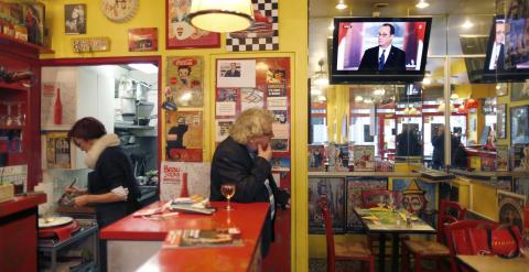 La rueda de prensa semestral del presidente frances Francois Hollande en un televisor de un bar en Paris. REUTERS/Charles Platiau