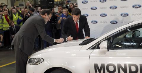 El presidente del Gobierno, Mariano Rajoy, y el presidente mundial de Ford, Mark Fields, firman sobre un vehículo durante la visita que han realizado a la fábrica de Ford en Almussafes, en la Comunidad Valenciana. EFE/Kai Försterling
