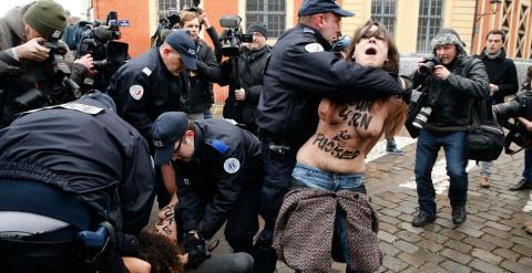 Un policía intenta retener a una joven de Femen. /REUTERS