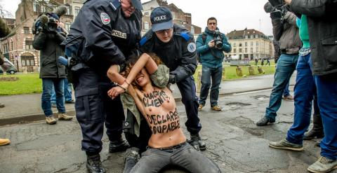 Una joven de Femen arrodilada y maniatada por la Policía. /AFP