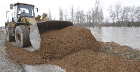 Tabajos para evitar que el río Ebro se desborde a su paso por la localidad zaragozana de Pradilla, donde muchos los vecinos, que han estado toda la noche pendientes del nivel de las aguas, han sido desalojados como medida preventiva. EFE/Javier Belver