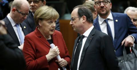 La canciller alemana Angela Merkel conversa con el presidente francés Francois Hollande antes del comienzo de la cumbre de Bruselas, en la que prevén mantener un encuentro aparte con el primer ministro griego Alexis Tsipras. REUTERS/Francois Lenoir