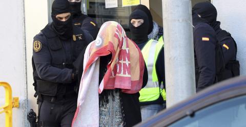 Agentes de la Guardia Civil escoltan a la mujer que, junto a su marido y a sus dos hijos gemelos, han sido detenidos en Badalona por la Guardia Civil por su presunta relación con una red de envío de yihadistas a Siria. EFE/Toni Garriga