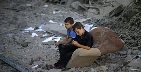 Niños palestinos tras un bombardeo de Israel. REUTERS