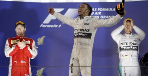 El piloto británico de Fórmula 1 Lewis Hamilton (Mercedes ) celebra en el podio su victoria en la carrera del circuito de Baréin. Por detrás de él has entrado en meta Kimi Raikkonen (Ferrari) y Nico Rosberg (Mercedes). REUTERS/Ahmed Jadallah