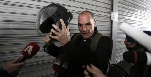 El ministro de Finanzas griego, Yanis Varufakis, rodeado de periodistas tras llegar en moto a una reunión en el Ministerio. - EFE