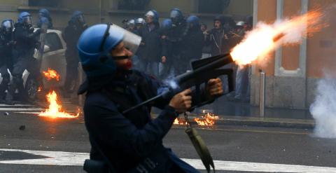 Un policía antidisturbios lanza gases lacrimógenos. - REUTERS
