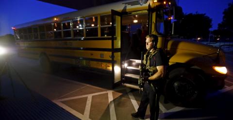 Un agente cerca de un autobús escolar. REUTERS/Mike Stone