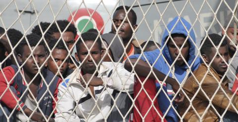 Migrantes africanos esperan a desembarca en el puerto siciliano de Palermo, tras se rescatados por un barco de la marina italiana. REUTERS/Guglielmo Mangiapane