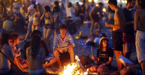 Varios jovenes aguardan alrededor de una hoguera en la playa de la Malvarrosa, en Valencia. /EFE