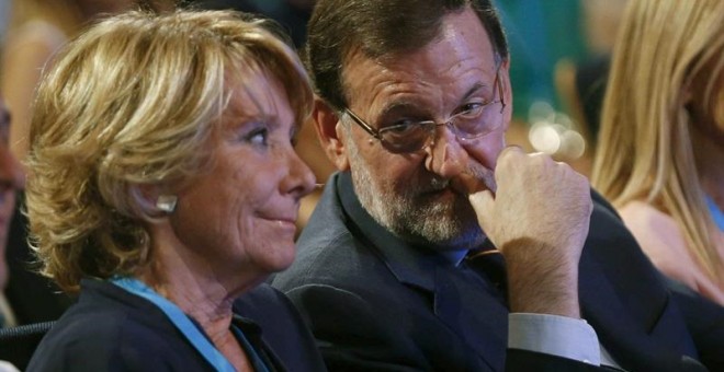 a portavoz del PP en el Ayuntamiento de Madrid, Esperanza Aguirre (i),conversa con el presidente del Gobierno, Mariano Rajoy en la Conferencia Política del PP. / PACO CAMPOS (EFE)
