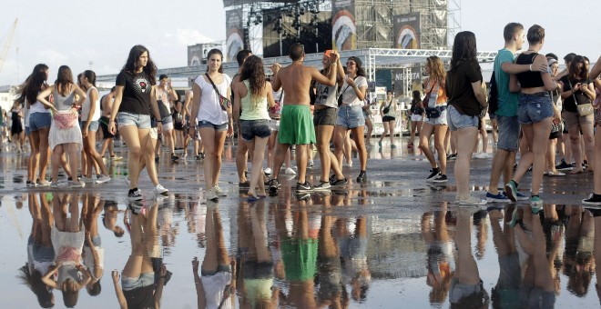 Varias jóvenes tras la tormenta registrada hoy en la primera jornada grande del festival Arenal Sound que se celebra en Burriana. EFE