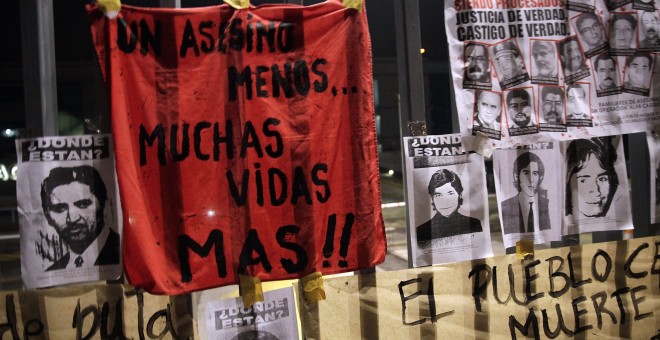 Varias personas se manifiestan tras la muerte del general Manuel Contreras en el hospital militar de Santiago (Chile). EFE/José Miguel Caviedes