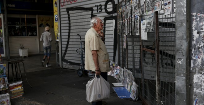 Un hombre lee los titulares de los periódicos expuestos en un quiosco en Atenas. REUTERS/Alkis Konstantinidis