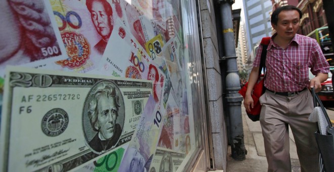 Un hombre que camina junto a una oficina de intercambio de divisas en Hong Kong, China. EFE/YM YIK