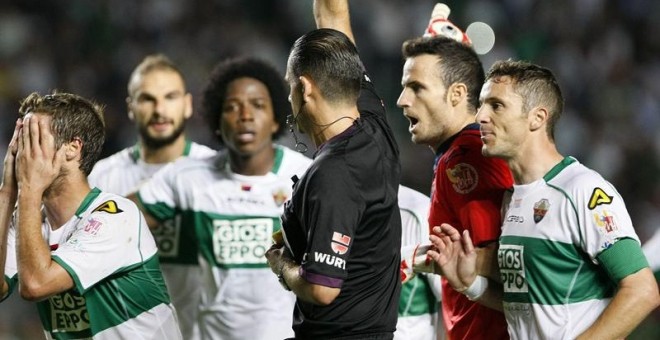 Los jugadores del Elche protestan ante el árbitro Muñiz Fernández por un penaly en contra del equipo. EFE