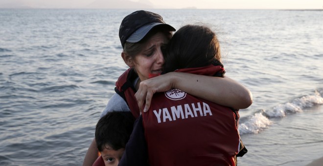 Una mujer abraza a sus hijos momentos después de llegar a la orilla de la isla griega de Kosk./ REUTERS