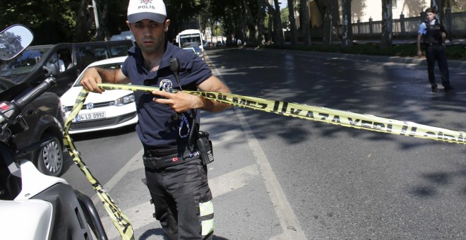 Un policía turco coloca una cinta para acotar la zona cercana al Palacio de Dolmabahçe, en Estambul, donde se ha producido un tiroteo. REUTERS/Murad Sezer